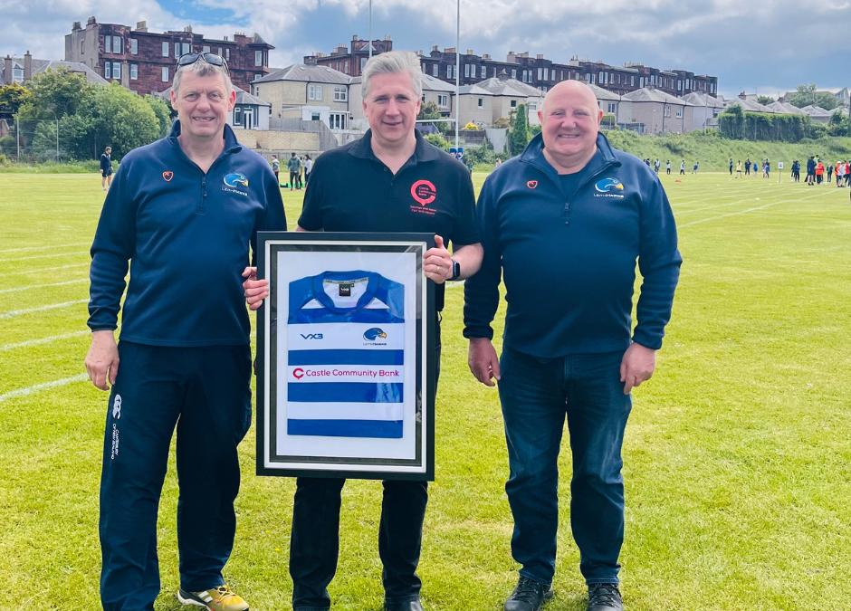 Alex and Russell from Leith Rugby Youth Development present Castle Community Bank CEO Adrian Sargent with framed sponsored shirt